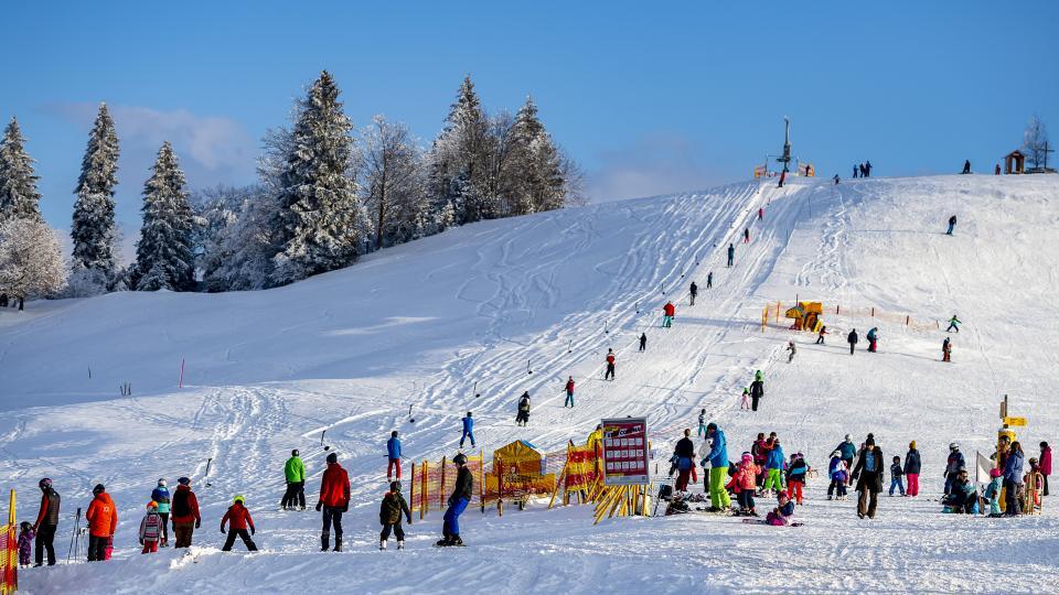 Der kleine Skilift Raten, eingebettet in der verschneiten Winterlandschaft, wird rege von Schneesporttreibenden benutzt..