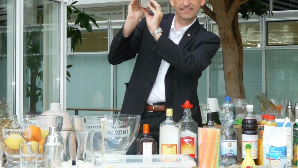 Kursleiter vom Cocktail-Mix Workshop posiert mit Schüttel-Becher